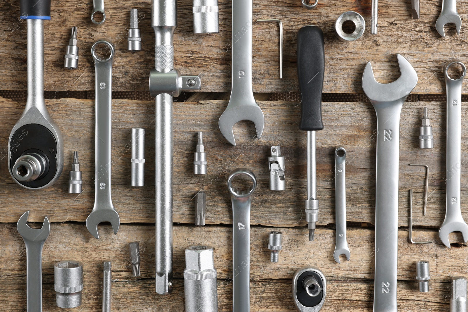 Photo of Different auto mechanic's tools on wooden table, flat lay