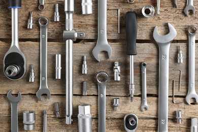 Different auto mechanic's tools on wooden table, flat lay