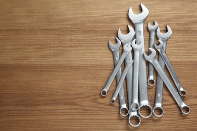 Photo of Auto mechanic's tools on wooden table, top view. Space for text