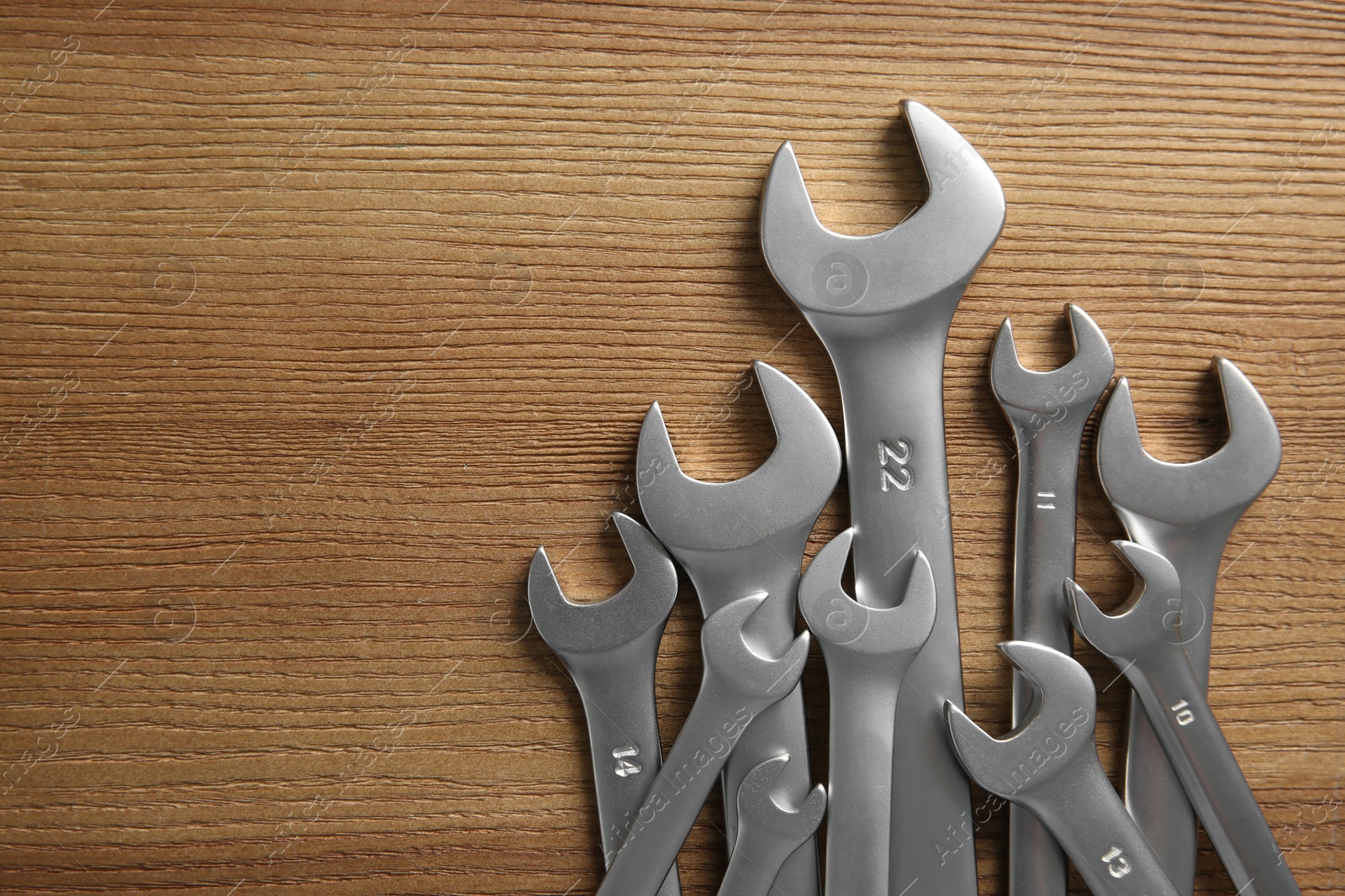 Photo of Auto mechanic's tools on wooden table, top view. Space for text