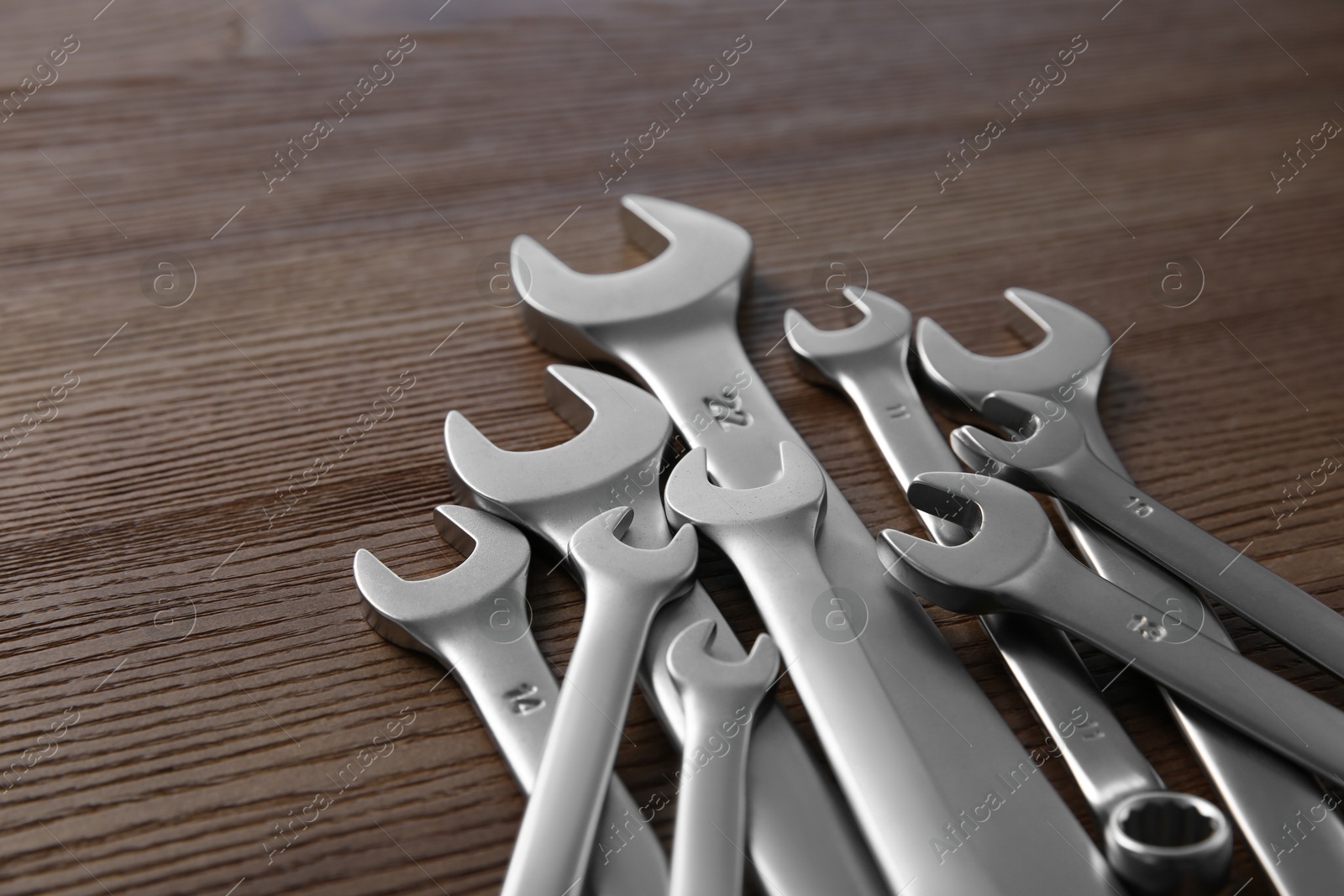 Photo of Many auto mechanic's tools on wooden table, closeup