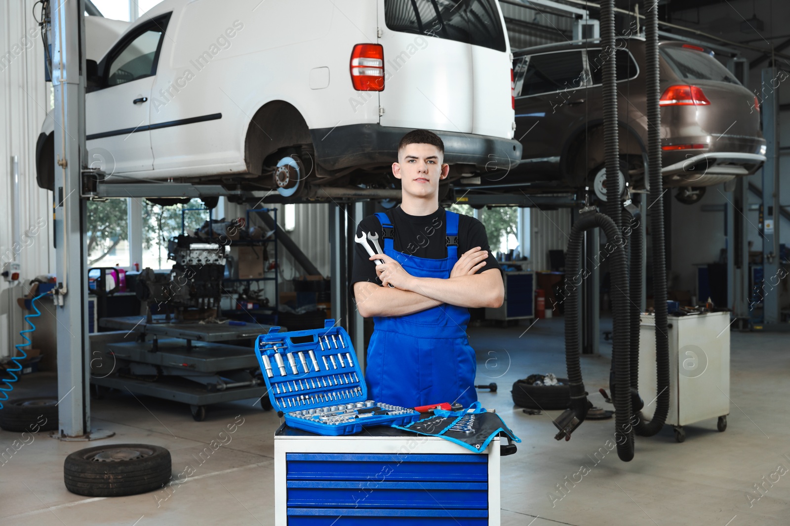 Photo of Young auto mechanic with different tools at automobile repair shop