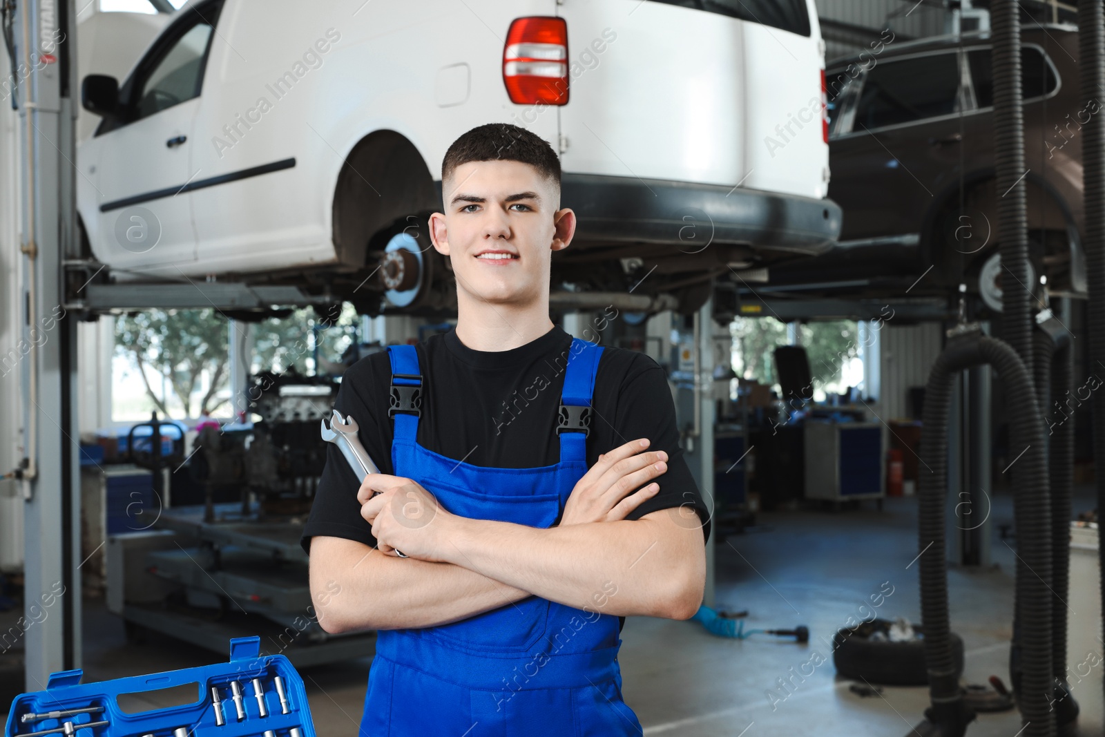 Photo of Young auto mechanic with wrenches at automobile repair shop