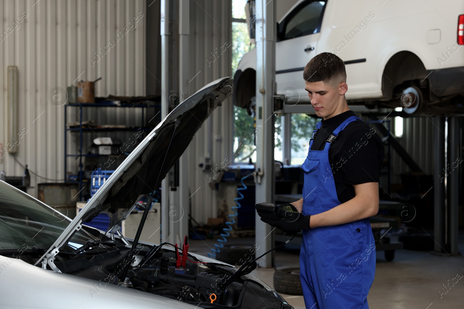 Photo of Young auto mechanic fixing car at automobile repair shop