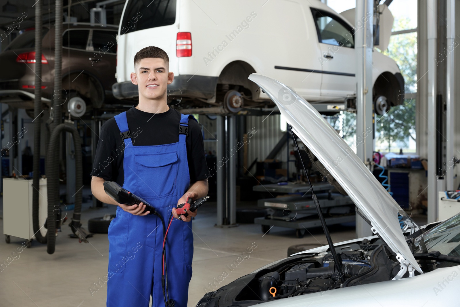 Photo of Young auto mechanic fixing car at automobile repair shop