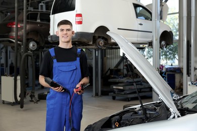 Young auto mechanic fixing car at automobile repair shop