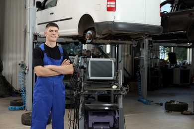 Photo of Young auto mechanic at automobile repair shop