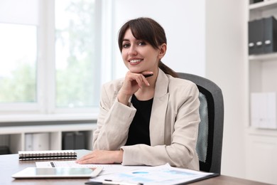 Portrait of smiling business consultant at table in office