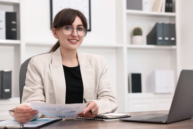 Photo of Portrait of smiling business consultant at table in office