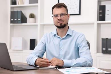 Portrait of business consultant at table in office