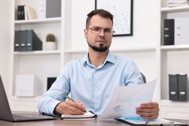 Portrait of business consultant at table in office