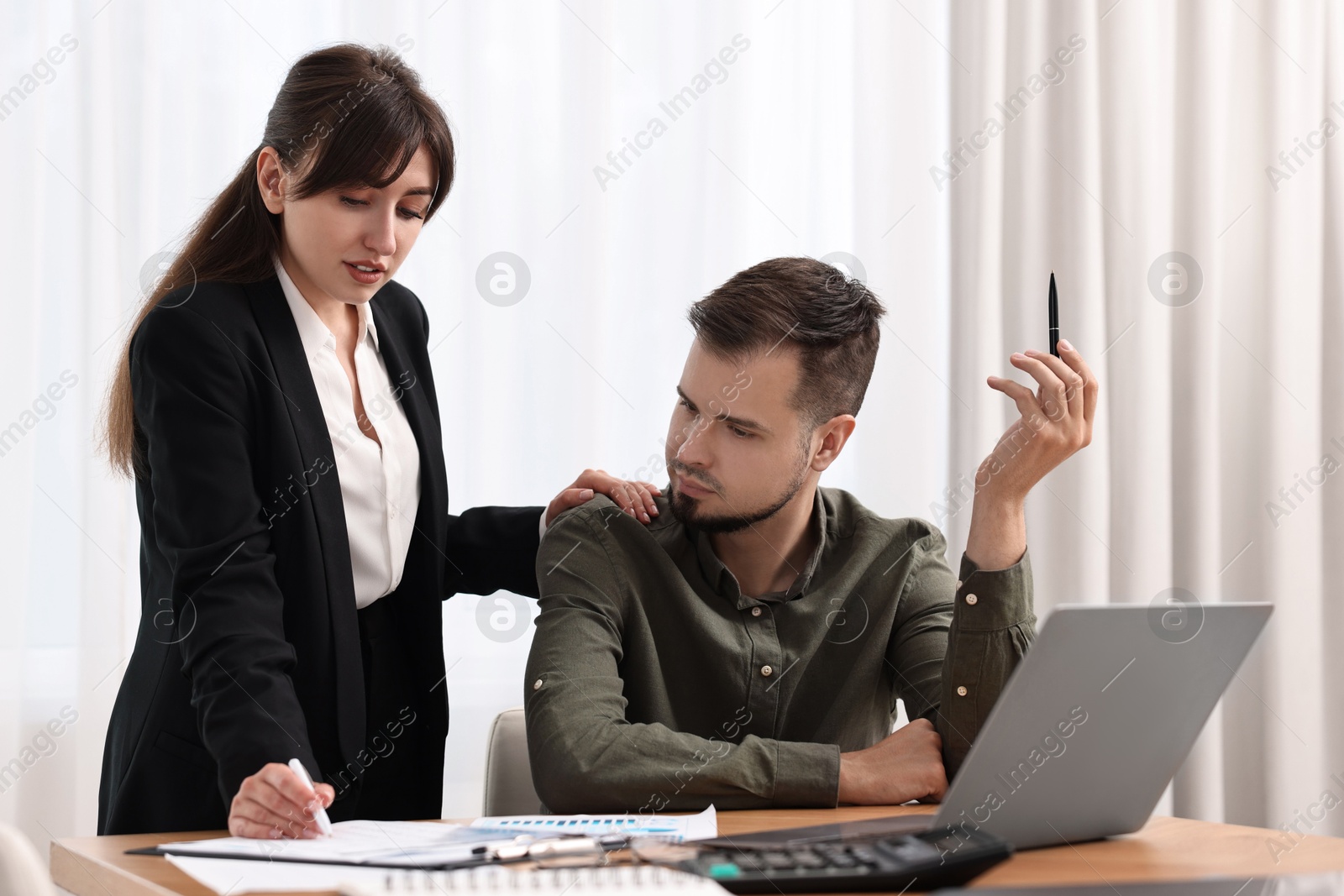 Photo of Consultant working with client at table in office. Business meeting