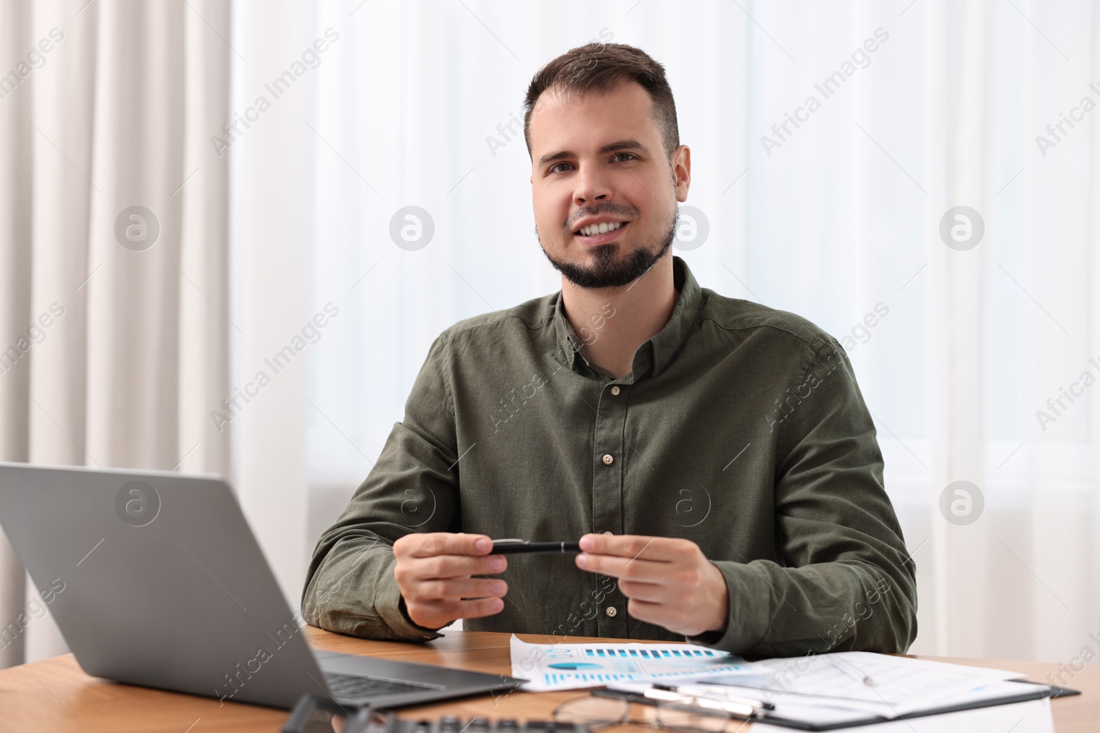 Photo of Portrait of smiling business consultant at table in office