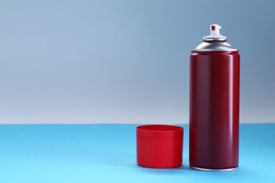 Photo of Red spray paint can on color background, space for text