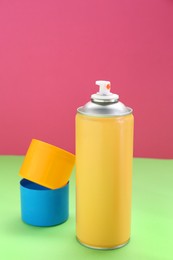 Yellow spray paint can on color background