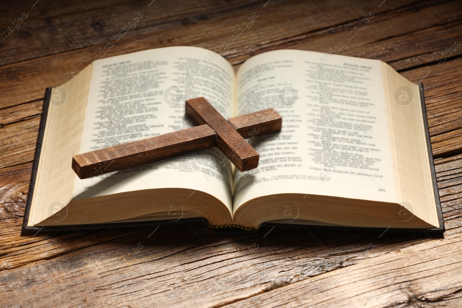 Photo of Bible and cross on wooden table. Religion of Christianity