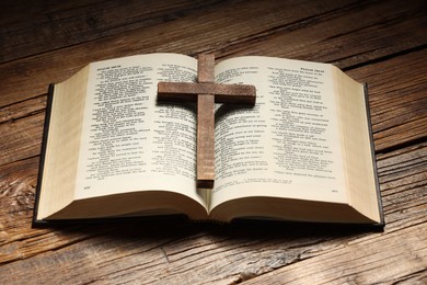 Photo of Bible and cross on wooden table. Religion of Christianity