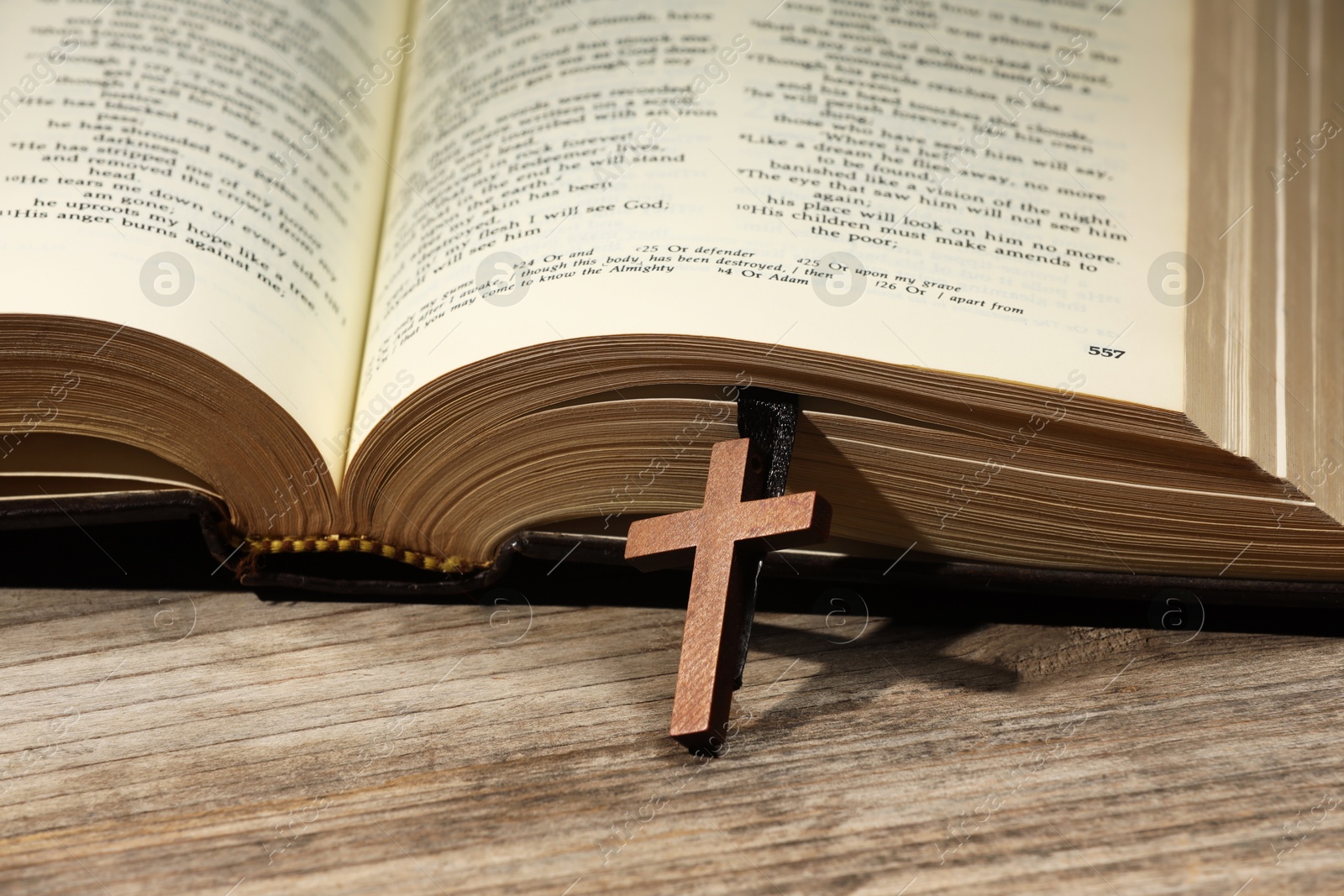 Photo of Bible and cross on wooden table, closeup. Religion of Christianity