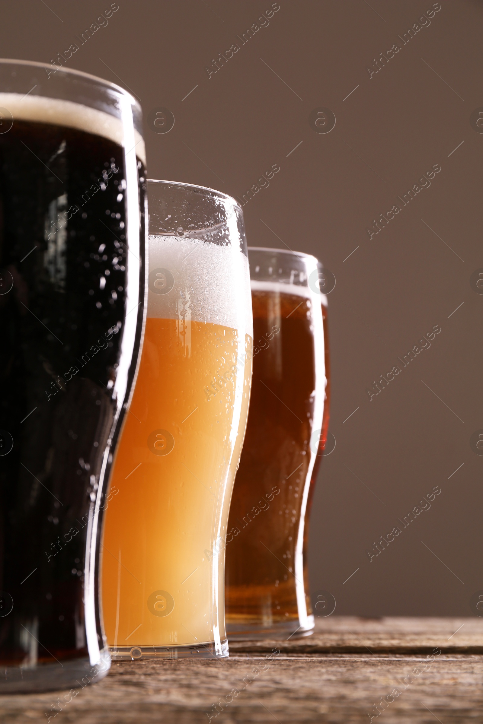 Photo of Glasses with different types of beer on wooden table, closeup