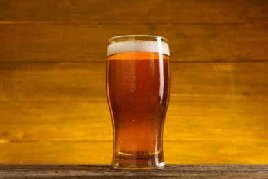 Photo of Glass of cold beer on wooden table