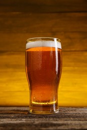 Photo of Glass of cold beer on wooden table