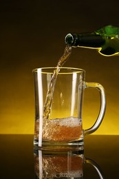 Photo of Pouring beer into glass mug from bottle on dark table, closeup