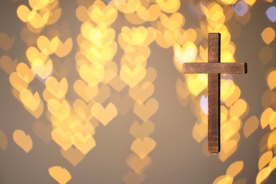 Photo of Wooden cross against blurred lights, closeup with space for text. Religion of Christianity