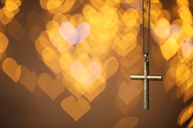 Photo of Wooden cross against blurred lights, closeup with space for text. Religion of Christianity