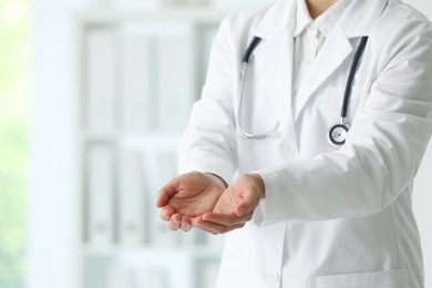 Photo of Doctor with stethoscope holding something in clinic, closeup