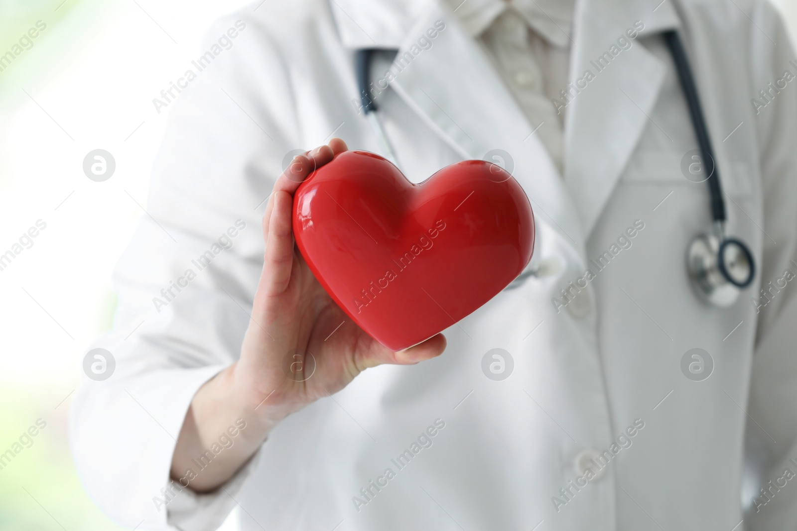 Photo of Doctor with red heart in clinic, closeup