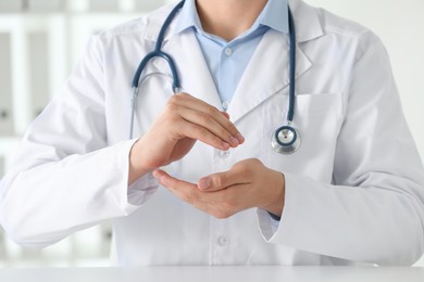 Photo of Doctor holding something at white table in clinic, selective focus