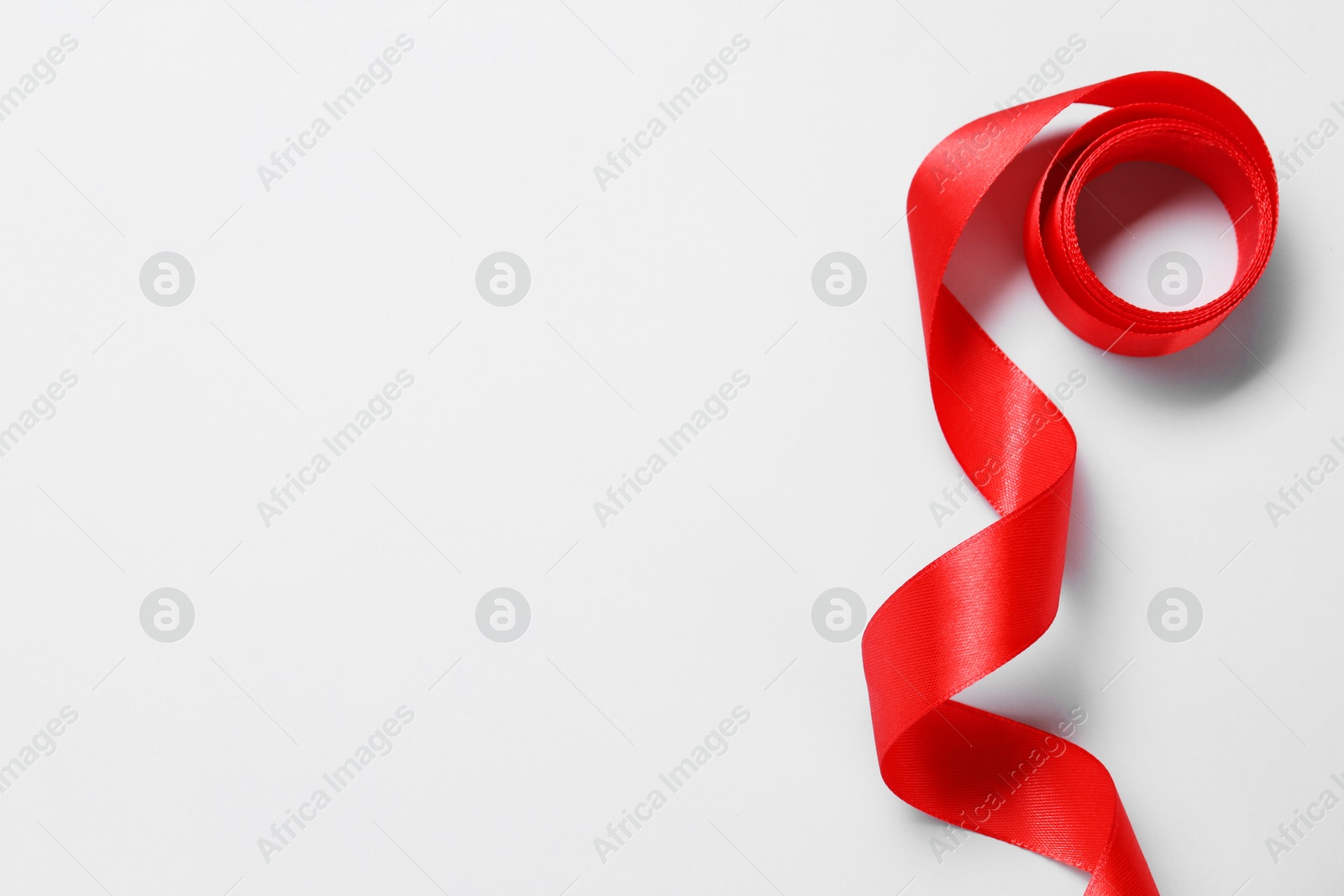 Photo of One beautiful red ribbon on white background