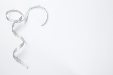 Photo of One beautiful grey ribbon on white background, top view. Space for text