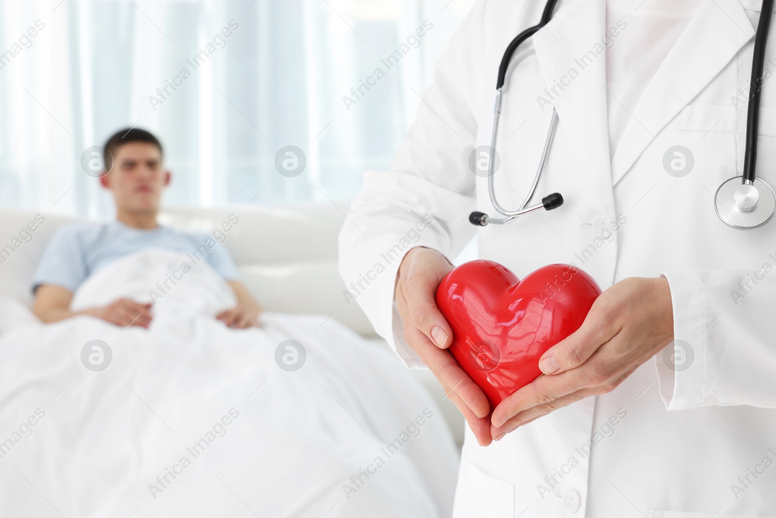 Photo of Doctor holding red heart in clinic, selective focus