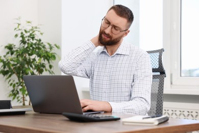 Man suffering from neck pain in office. Symptom of poor posture