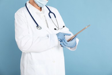 Photo of Doctor with tablet on light blue background, closeup view