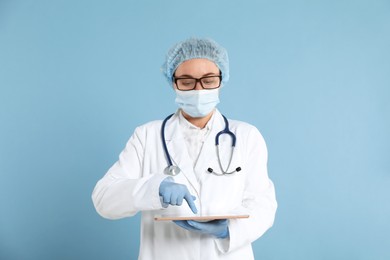 Photo of Doctor with tablet on light blue background