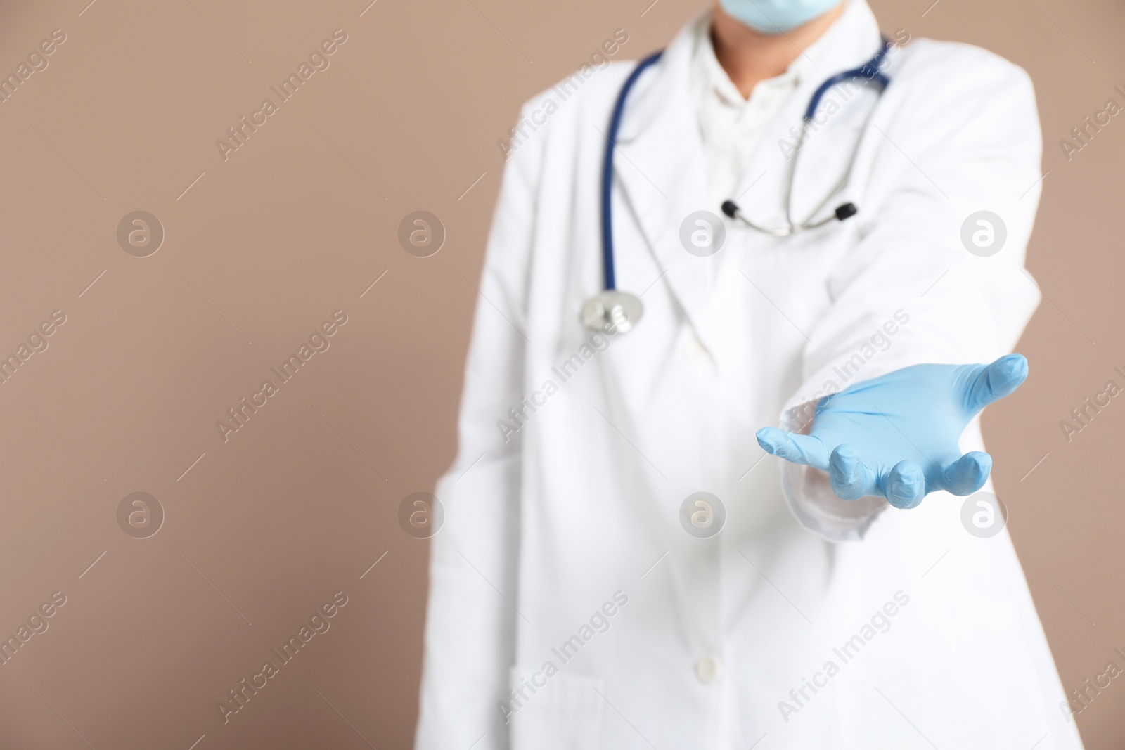 Photo of Doctor holding something on beige background, closeup. Space for text