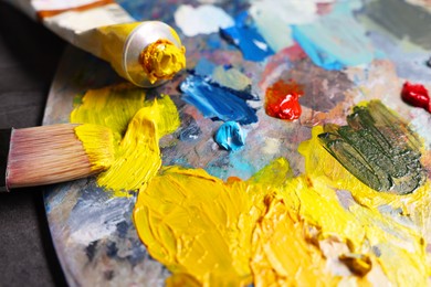 Artist's palette, brush and paints on grey table, closeup