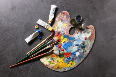 Artist's palette, brushes and paints on grey table, flat lay