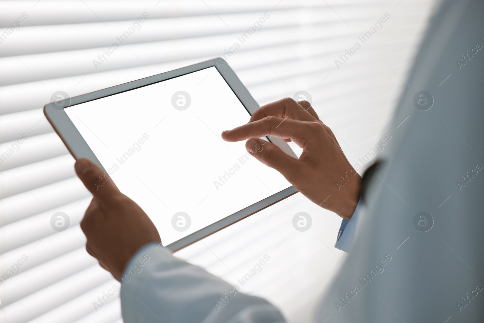 Photo of Doctor using tablet in hospital, closeup view