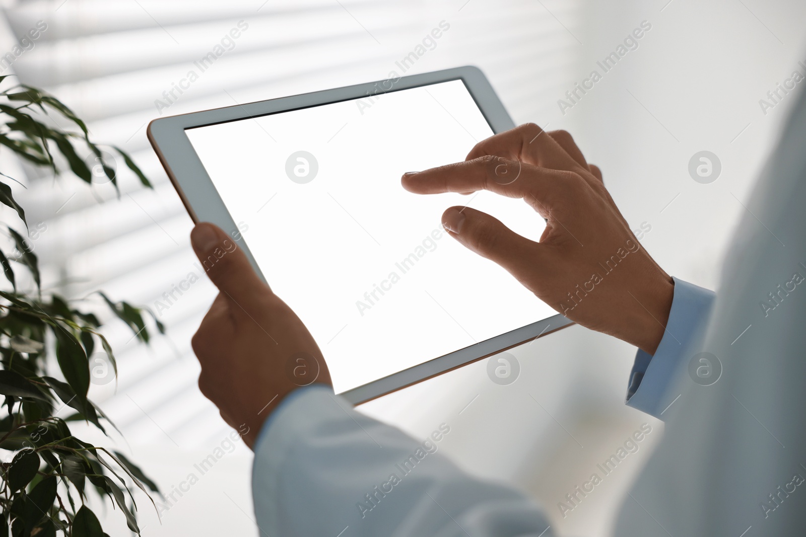 Photo of Doctor using tablet in hospital, closeup view