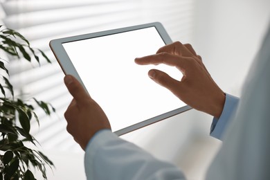 Photo of Doctor using tablet in hospital, closeup view