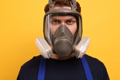 Man in respirator mask on yellow background