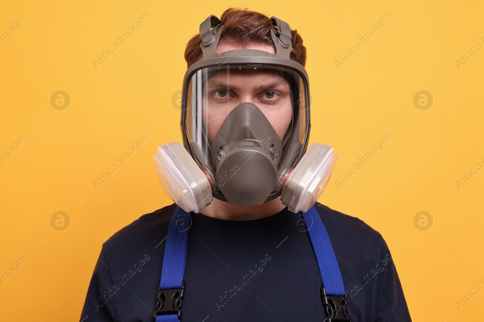 Photo of Man in respirator mask on yellow background