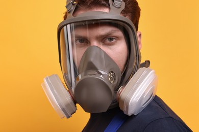 Man in respirator mask on yellow background