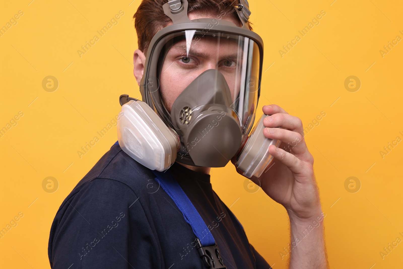 Photo of Man in respirator mask on yellow background