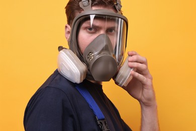 Man in respirator mask on yellow background