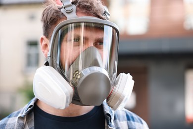 Photo of Man in respirator mask outdoors. Safety equipment