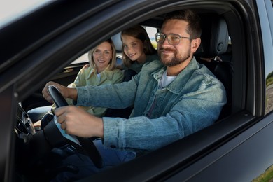 Happy family enjoying trip together by car, view from outside